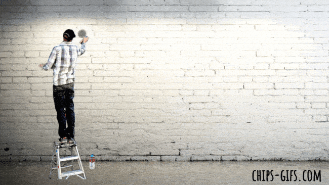  A group of young people spray painting the word 'resist' on the side of a building